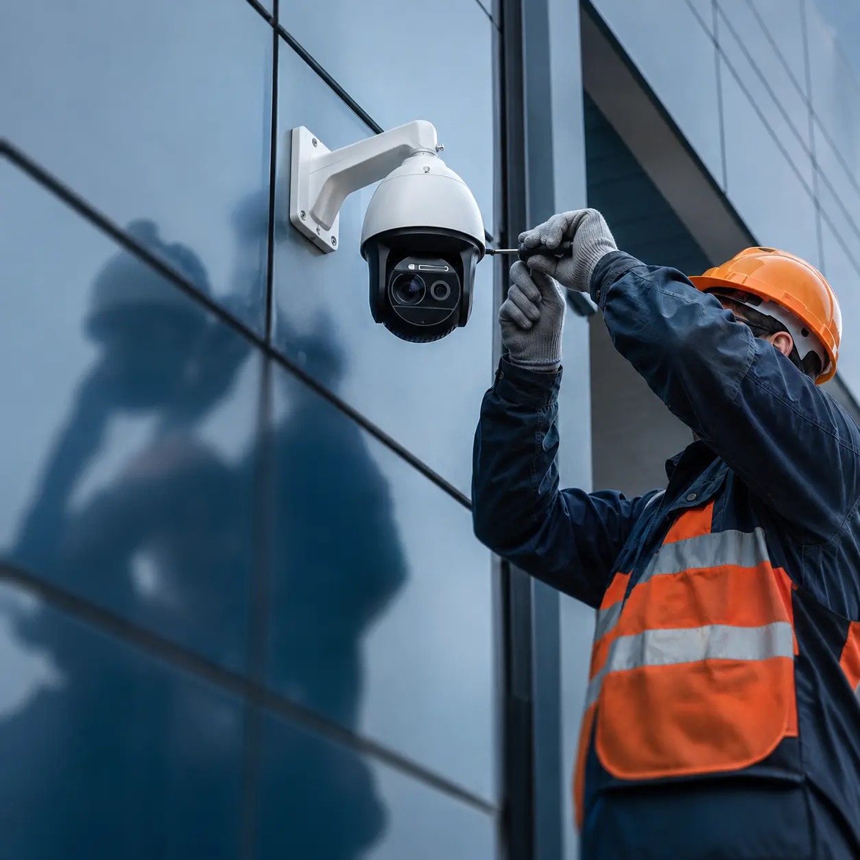 Technician installing a commercial building security camera